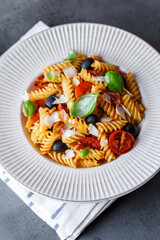 Pasta fusilli with cherry tomatoes, basil and olives. Homemade pasta 