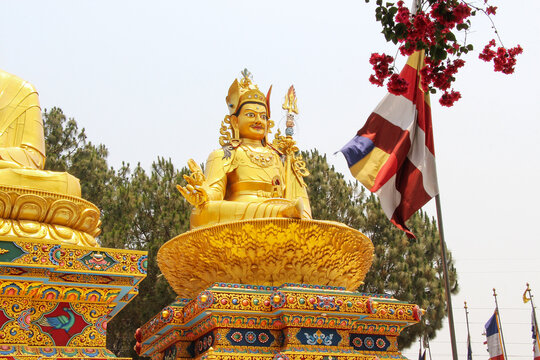 Large gold colored Guru Rinpoche (also known as Padmasambhava) statue in sunny day in Amideva Buddha Park located in the western part of Kathmandu city, Nepal. Religious architecture theme.