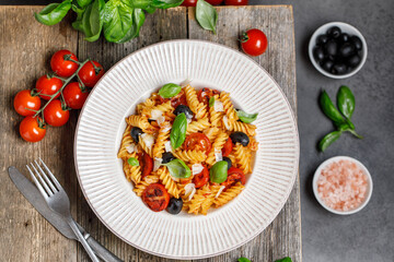 Pasta fusilli with cherry tomatoes, basil and olives. Homemade pasta 