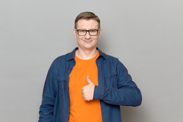 Portrait of happy man raising thumb up in approval and like gesture