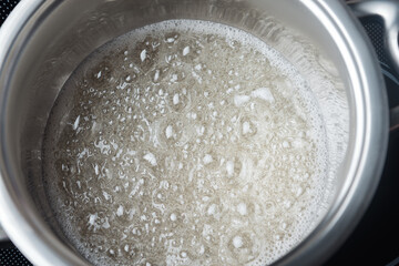 Boiling sugar syrup in a stainless steel pan.