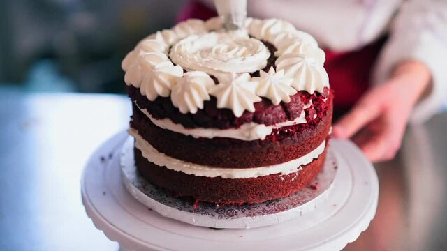 CU SELECTIVE FOCUS Confectioner adding cream to red velvet cake / Florence, Tuscany, Italy