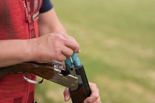 Close up of a man reloading his rifle.