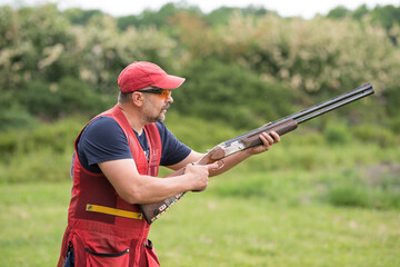 Man shooting skeet with a shotgun. © Milkica