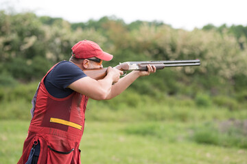 Man shooting skeet with a shotgun.