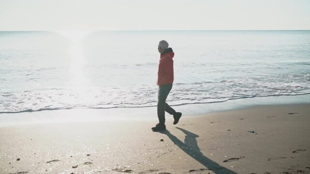 WS SLO MO TS Man walking on beach / Rosignano, Livorno, Italy
