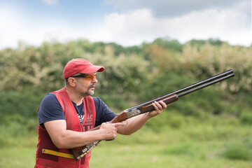 Man shooting skeet with a shotgun.