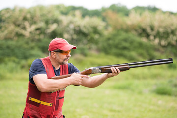 Man shooting skeet with a shotgun. Skeet shooting, trap shooting.