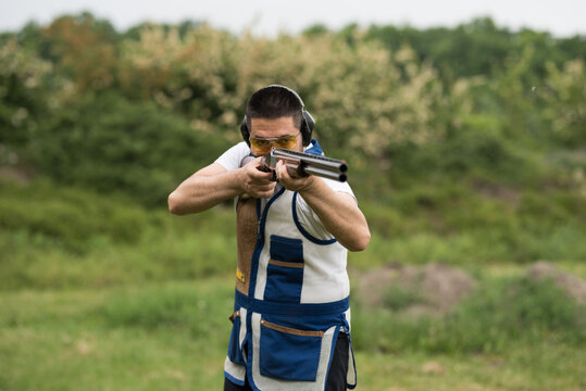 Man shooting skeet with a shotgun.