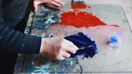 CU Woman adding pigment to paint and mixing with spatula / Yekaterinburg, Ural, Russia