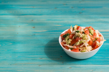 Vegetarian salad of fresh vegetables with olive oil on a blue wooden table