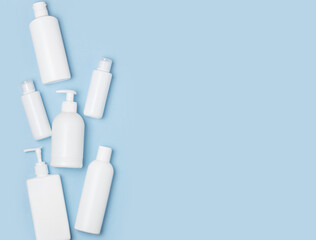White plastic cans on a blue background. Cosmetics for skin care. Means for washing, disinfecting and washing