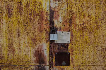 Rusty, iron fence. Metal gate. Padlock.