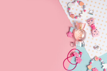 Children's flat lay. Perfume in the form of candy, children's jewelry and hair accessories on a...