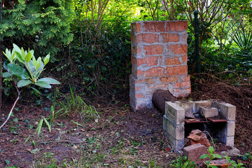 a self-made brick smokehouse standing in the yard of a country house