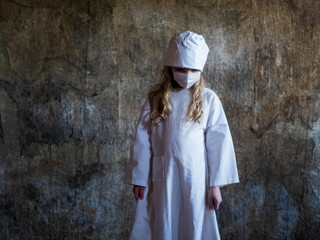 Teen girl playing nurse medicine. child is wearing white medical gown and face mask