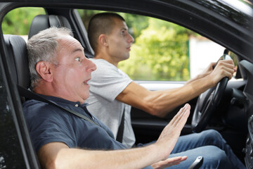 scared and shocked passanger and driver in a car