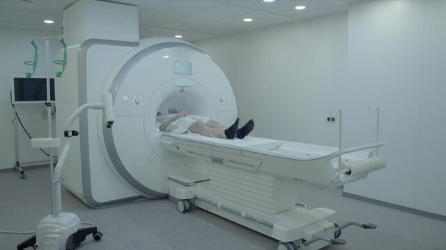 Lockdown shot of young patient lying on bed during MRI scan at hospital - Erfurt, Germany