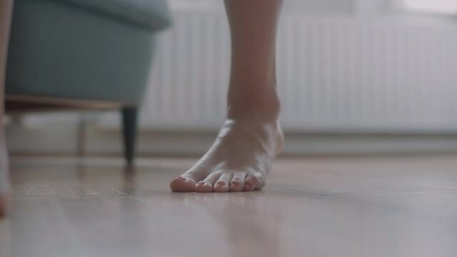 Close up of woman's feet as she walks across the floor