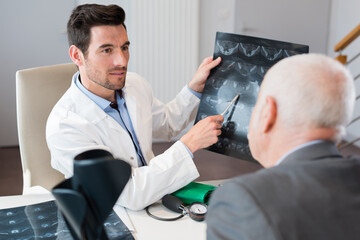 doctor discussing xray with senior male patient