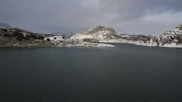 Agua Embalsada en Pantano Rodeado de Monta&ntilde;as con nieve en invierno . Pantano del Rio Porma en Leon Espa&ntilde;a