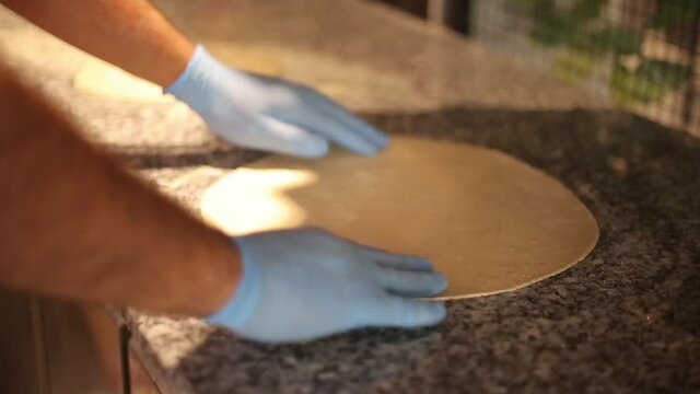 chef is preparing dough for pizza.Italian food,cooking pizza.The process of making pizza.