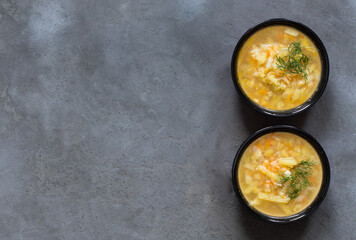 Vegetable soup of cabbage, potatoes, carrots with dill on a bowl top view copy space