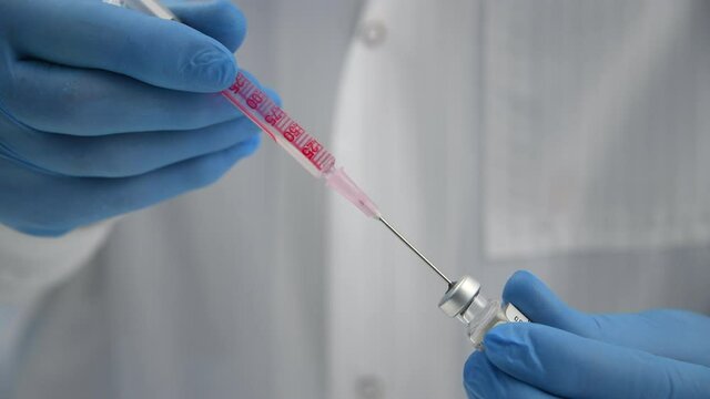 CU SELECTIVE FOCUS Doctor preparing drug dose for patient / High Wycombe, Bucks, UK