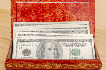 American hundred dollar bills in large quantities in a wooden box