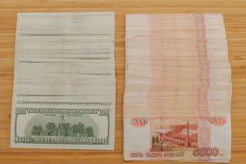 A large number of American hundred dollar bills and Russian five thousand dollar bills