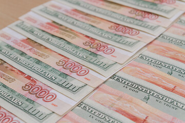Fototapeta na wymiar A large number of American hundred dollar bills and Russian five thousand dollar bills
