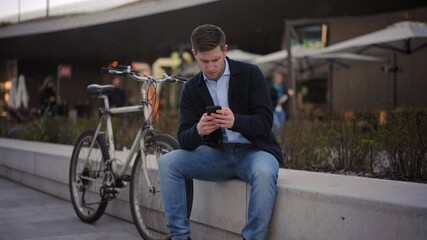 MS Businessman sitting on wall and using phone / Milano, Milano, Italy