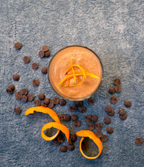 orange and chocolate mousse on blue textured background, top view. The concept of clean, diet,...