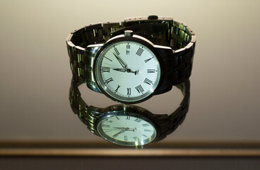 Some stylish modern watches on a reflective table.
