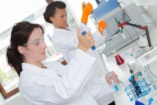female scientists using pipettes in lab
