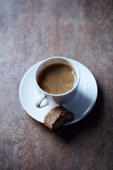 Cup of coffee with cantuccini (Italian biscuits) on rustic stone background.