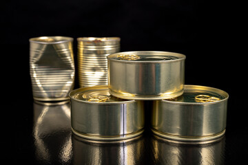 Metal cans with food on a dark table. Preserved meal with a long shelf life.