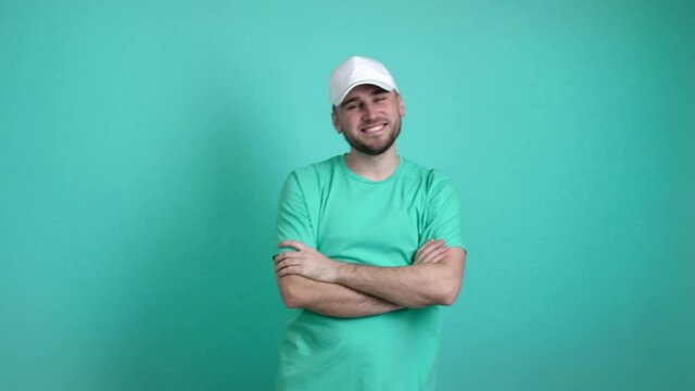 Handsome man putting on stylish cap against color background