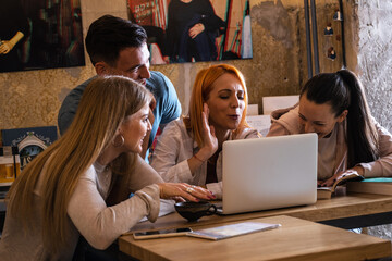 Group of university students hangout at the  campus cafe on coffee break.Reading something on internet.