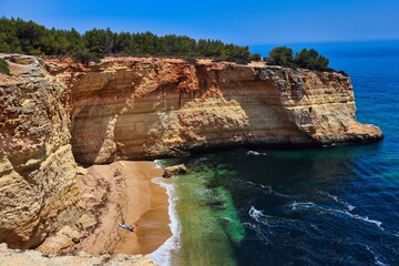 A picture of a beach with Atlanic ocean and its waves, sandstone cliffs on the way to see Benagil cave from above. 