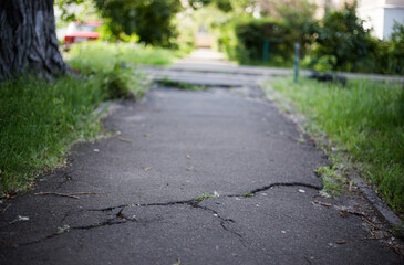 Broken asphalt and cracks on the road surface