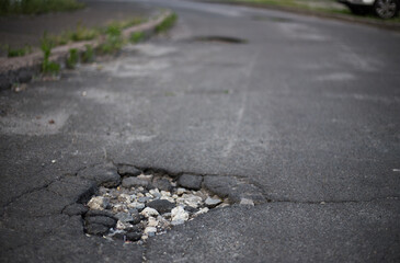 Broken asphalt and cracks on the road surface