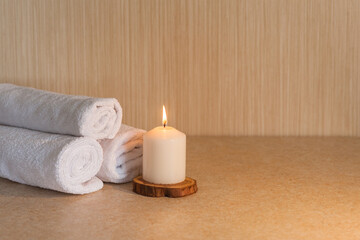Obraz na płótnie Canvas Spa, beauty and wellness. Towels and candle on a wooden stand. Minimal concept