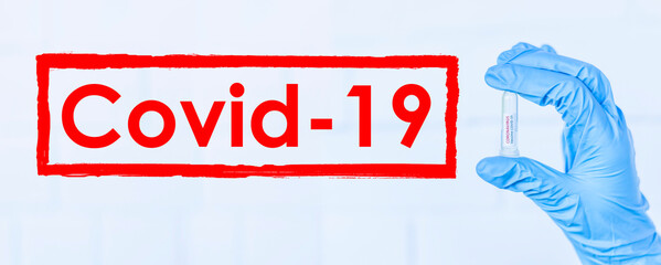 Hand holds a test tube containing a blood sample, test tube with blood for Covid-19 (coronavirus) analyzing