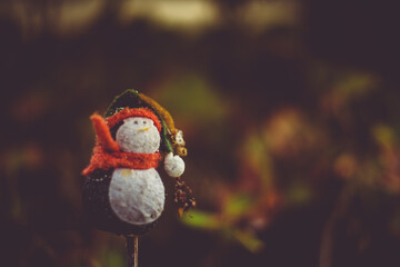 Forgotten christmas toy in the middle of the forest, with nice autumn colors blurry background