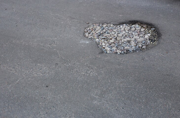 Broken asphalt and cracks on the road surface