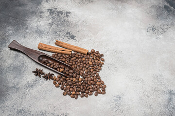 Coffee beans with a wooden spoon and cinnamon sticks