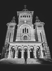 Fine art image of Orthodox cathedral in Timisoara with tourist standing in front of the entrance and looking up. Confession and religion in modern world.