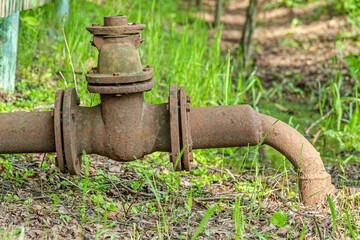rusty water pipe with a valve in the yard close up