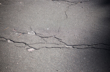 Obraz premium Broken asphalt and cracks on the road surface